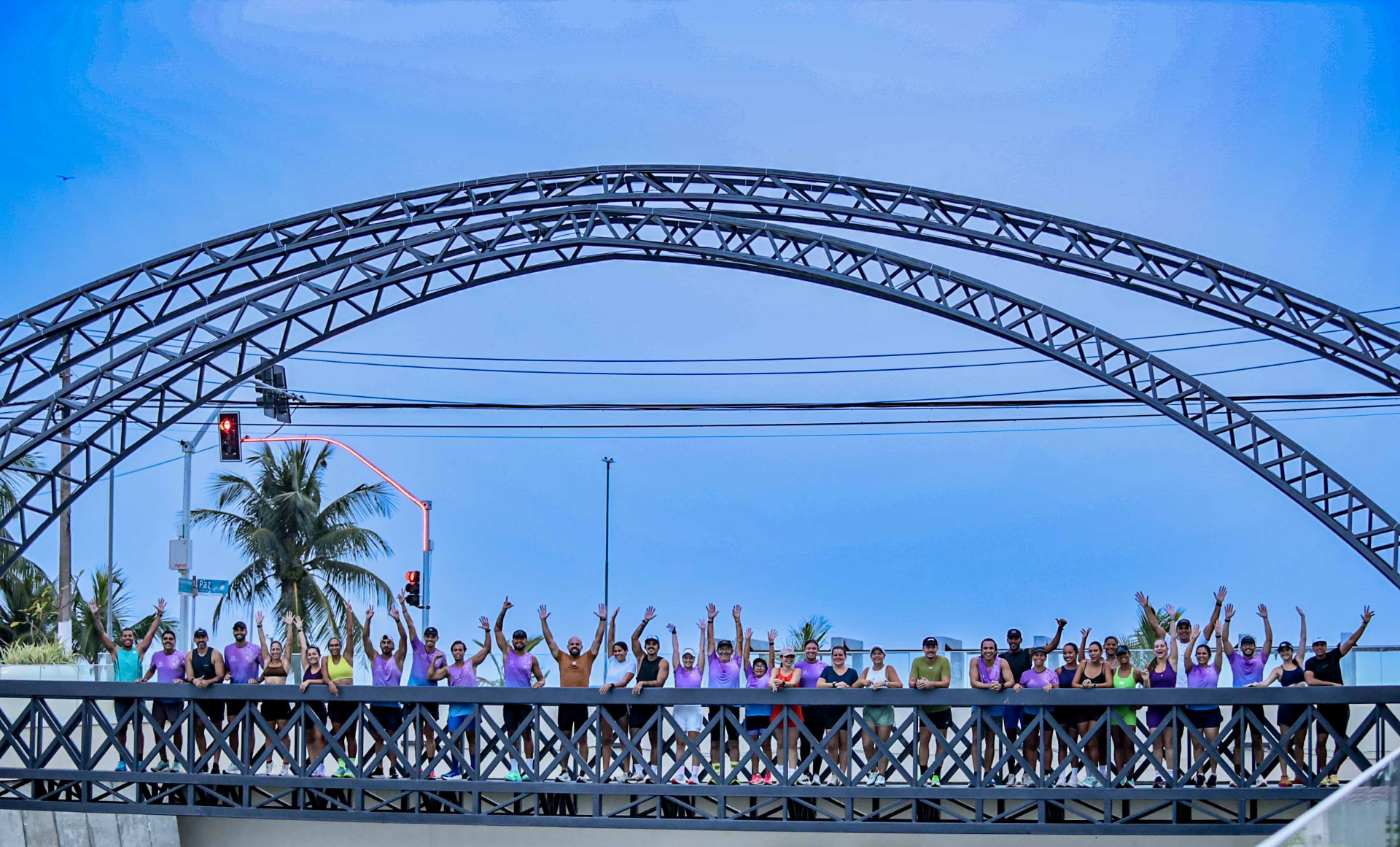 Alunos acenando sobre a passarela da orla de Maceió
